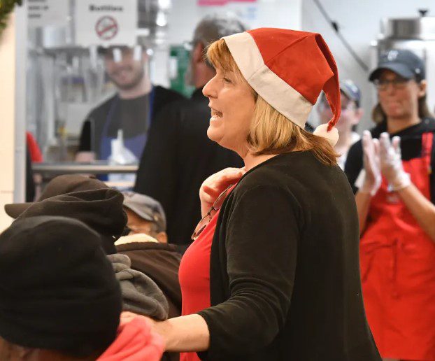 Karen LaFrazia, CEO of St. Francis House, talks to guests at the Christmas feast. (Chris Christo/Boston Herald)